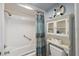 Nautical-themed bathroom with a shower/tub combo and decorative storage at 9 Forbes Pl # 512, Dunedin, FL 34698