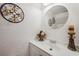 Charming powder room with decorative accents and oval mirror above a sleek white vanity at 9046 Lake Place Ln # 9046, Tampa, FL 33634