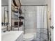 Bright bathroom with a vanity, shelving unit, and a tub-shower combo with a striped curtain at 9046 Lake Place Ln # 9046, Tampa, FL 33634