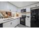 Modern kitchen with white cabinets, black appliances, and elegant countertops, perfect for cooking at 9046 Lake Place Ln # 9046, Tampa, FL 33634