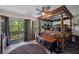 Main bedroom featuring a four-poster bed, outdoor views and wood floors at 9046 Lake Place Ln # 9046, Tampa, FL 33634