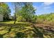 Expansive backyard with lush green grass and mature trees offers outdoor enjoyment at 9545 Sunshine Blvd, New Port Richey, FL 34654