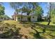 The backyard has a well-maintained lawn and mature trees with a view of the home's exterior at 9545 Sunshine Blvd, New Port Richey, FL 34654