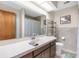 Well-lit bathroom featuring a large mirror, vanity, and tiled shower at 9545 Sunshine Blvd, New Port Richey, FL 34654