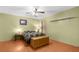 This bedroom has a wood floor, ceiling fan and side tables with lamps, giving a cozy feel at 9545 Sunshine Blvd, New Port Richey, FL 34654