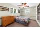 Cozy bedroom with a colorful patterned bed, wooden dresser, and built-in shelving at 9545 Sunshine Blvd, New Port Richey, FL 34654