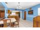 Bright kitchen and dining area with blue walls, tiled floors, and classic cabinets at 9545 Sunshine Blvd, New Port Richey, FL 34654