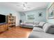 Inviting living room with plush sofa, bookcase and a window offering a comfortable space at 9545 Sunshine Blvd, New Port Richey, FL 34654