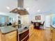 Open kitchen with an island, stainless steel oven and exhaust hood, wood floors, and a dining nook at 10136 Highcrest Ln, New Port Richey, FL 34654