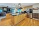 Bright kitchen features an island, stainless steel appliances, wood floors and a large window overlooking the pool at 10136 Highcrest Ln, New Port Richey, FL 34654