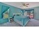 Bright bedroom with a queen bed, light-blue walls, and sliding door to pool deck at 10200 Swanson Ct, Spring Hill, FL 34608