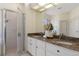 Bathroom featuring a granite countertop, double vanity, and a glass-enclosed shower at 1038 Greenturf Rd, Spring Hill, FL 34608