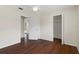 Comfortable bedroom features rich hardwood floors, ceiling fan, neutral colors, and open closet space at 1038 Greenturf Rd, Spring Hill, FL 34608