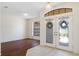 Welcoming foyer area featuring hardwood flooring, a chandelier, and decorative glass doors at 1038 Greenturf Rd, Spring Hill, FL 34608