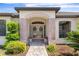 Beautiful front entrance featuring double doors, decorative wreaths, and lush landscaping at 1038 Greenturf Rd, Spring Hill, FL 34608