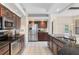Bright kitchen with dark wood cabinets, granite countertops, stainless steel appliances, and tile flooring at 1038 Greenturf Rd, Spring Hill, FL 34608