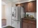 Kitchen area showcasing stainless steel refrigerator, granite countertops, and dark wood cabinetry at 1038 Greenturf Rd, Spring Hill, FL 34608