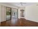 Open-concept living area featuring hardwood floors and access to the screened lanai and pool at 1038 Greenturf Rd, Spring Hill, FL 34608