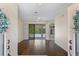 Bright living room with hardwood floors and sliding glass doors leading to the pool area at 1038 Greenturf Rd, Spring Hill, FL 34608