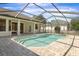 Gorgeous screened-in pool with brick surround and multiple entrances to the home at 1038 Greenturf Rd, Spring Hill, FL 34608