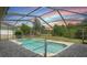 Screened-in pool with beautiful brick pavers and a view of the expansive backyard at 1038 Greenturf Rd, Spring Hill, FL 34608