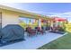 Relaxing back porch with patio furniture, a grill, and views of the landscaped yard at 1051 Almondwood Dr, Trinity, FL 34655