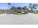 Visitors entrance to gated community with attractive landscaping and multiple palm trees, creating a welcoming atmosphere at 1051 Almondwood Dr, Trinity, FL 34655