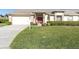 Inviting home featuring a red front door, brick accents, and a lush green lawn at 1051 Almondwood Dr, Trinity, FL 34655