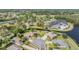 Scenic aerial view of the community featuring lush landscaping, community amenities, and tranquil pond at 11428 Hidden Cove Ct, Trinity, FL 34655