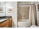 Bathroom features a tiled shower with a shower curtain and vanity with granite countertop at 11428 Hidden Cove Ct, Trinity, FL 34655