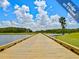 Picturesque view of a wooden bridge winding through the golf course, surrounded by lush greenery and serene water features at 11428 Hidden Cove Ct, Trinity, FL 34655