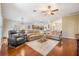 Open-concept living room with hardwood floors, ceiling fan and comfortable seating at 11428 Hidden Cove Ct, Trinity, FL 34655