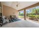 Screened patio area with tile flooring, ceiling fan and outdoor furniture overlooking landscaping at 11428 Hidden Cove Ct, Trinity, FL 34655
