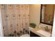 Well-lit bathroom with a granite countertop and a tropical shower curtain at 12820 Wedgewood Way # D, Hudson, FL 34667