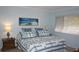 Comfortable bedroom with light blue walls and beach themed decor, featuring a cozy bed and ample natural light at 12820 Wedgewood Way # D, Hudson, FL 34667