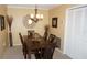 This carpeted dining room features a wooden table with seating for six and a modern chandelier at 12820 Wedgewood Way # D, Hudson, FL 34667