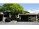 A two-story condo featuring an assigned carport under a mature tree in a landscaped community at 12820 Wedgewood Way # D, Hudson, FL 34667