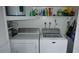 Efficient laundry room with side by side washer and dryer, plus storage shelving at 12820 Wedgewood Way # D, Hudson, FL 34667