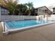 Community swimming pool surrounded by lounge chairs and landscaping at 12820 Wedgewood Way # D, Hudson, FL 34667