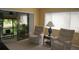 Cozy sunroom featuring wicker furniture, neutral carpeting, and a view of the verdant outdoors at 12820 Wedgewood Way # D, Hudson, FL 34667