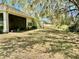 Spacious backyard with well-maintained lawn and mature trees near the screened patio at 13648 Crest Lake Dr, Hudson, FL 34669