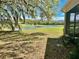 Backyard view showcasing a serene pond, lush greenery, and screened lanai at 13648 Crest Lake Dr, Hudson, FL 34669