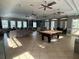 Large clubhouse featuring several sofas, a pool table, and large open windows at 13648 Crest Lake Dr, Hudson, FL 34669
