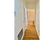 Hallway leading to bathroom showcasing wood floors and a neutral color palette at 13648 Crest Lake Dr, Hudson, FL 34669