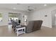 Spacious living room featuring neutral tile floors and a sliding glass door leading to the pool area at 14604 Strathglass Dr, Hudson, FL 34667