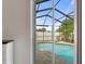 Screened-in pool with brick patio seen through sliding glass doors brings the outside in at 14604 Strathglass Dr, Hudson, FL 34667