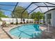 Inviting screened-in pool area with brick pavers, a lounge chair, and a view of the landscaped backyard at 14604 Strathglass Dr, Hudson, FL 34667