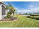Professionally landscaped backyard with lush lawn, brick border, and waterfront view at 1809 Westerham Loop, Trinity, FL 34655