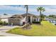 Charming single-story home with a well-manicured lawn, lush landscaping, and two-car garage located waterfront at 1809 Westerham Loop, Trinity, FL 34655