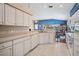 Modern kitchen with white cabinets, a breakfast bar, and an open layout overlooking the living and dining areas at 1809 Westerham Loop, Trinity, FL 34655